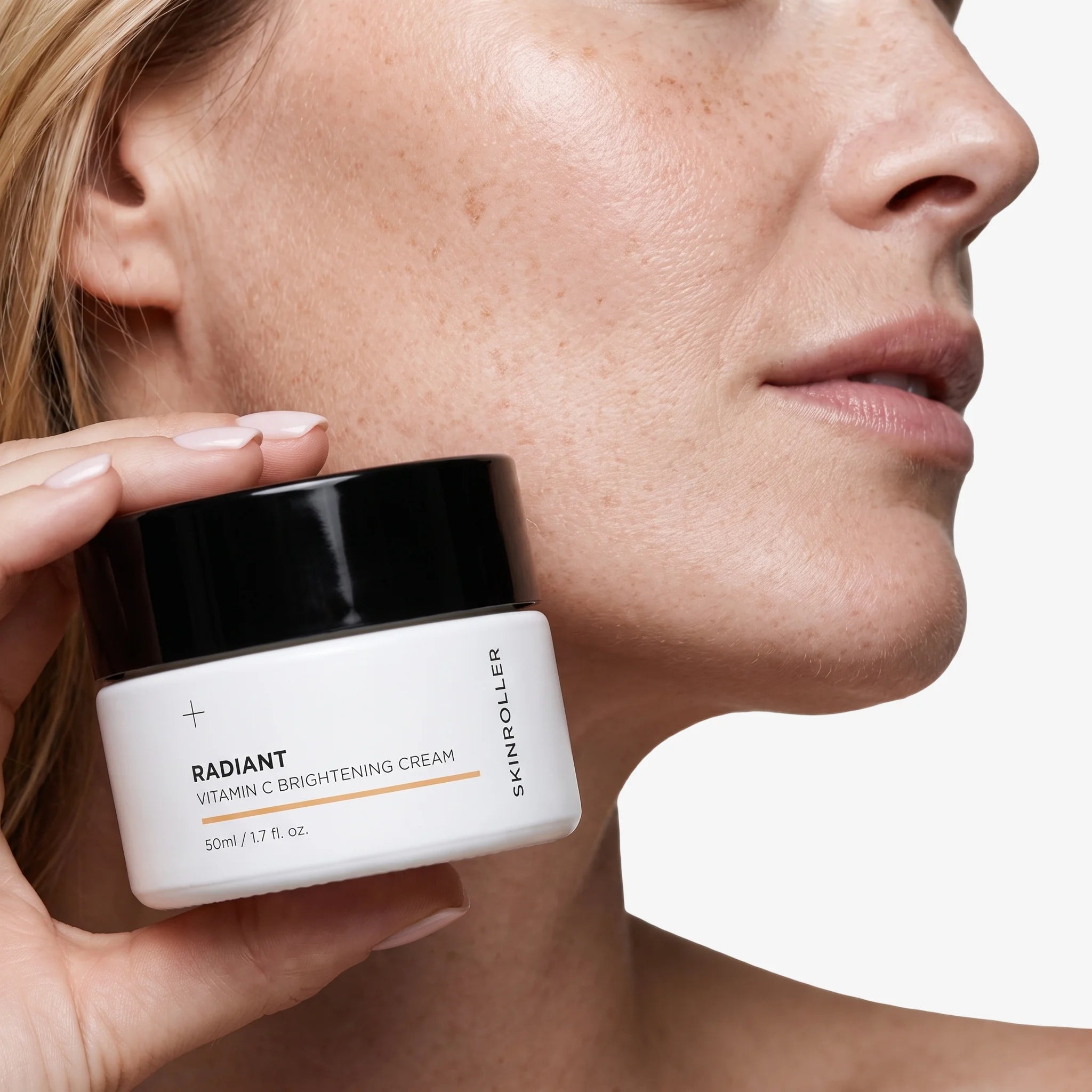 Image of Modell håller Skinroller Radiant Vitamin C Brightening Cream 50ml mot ansiktet