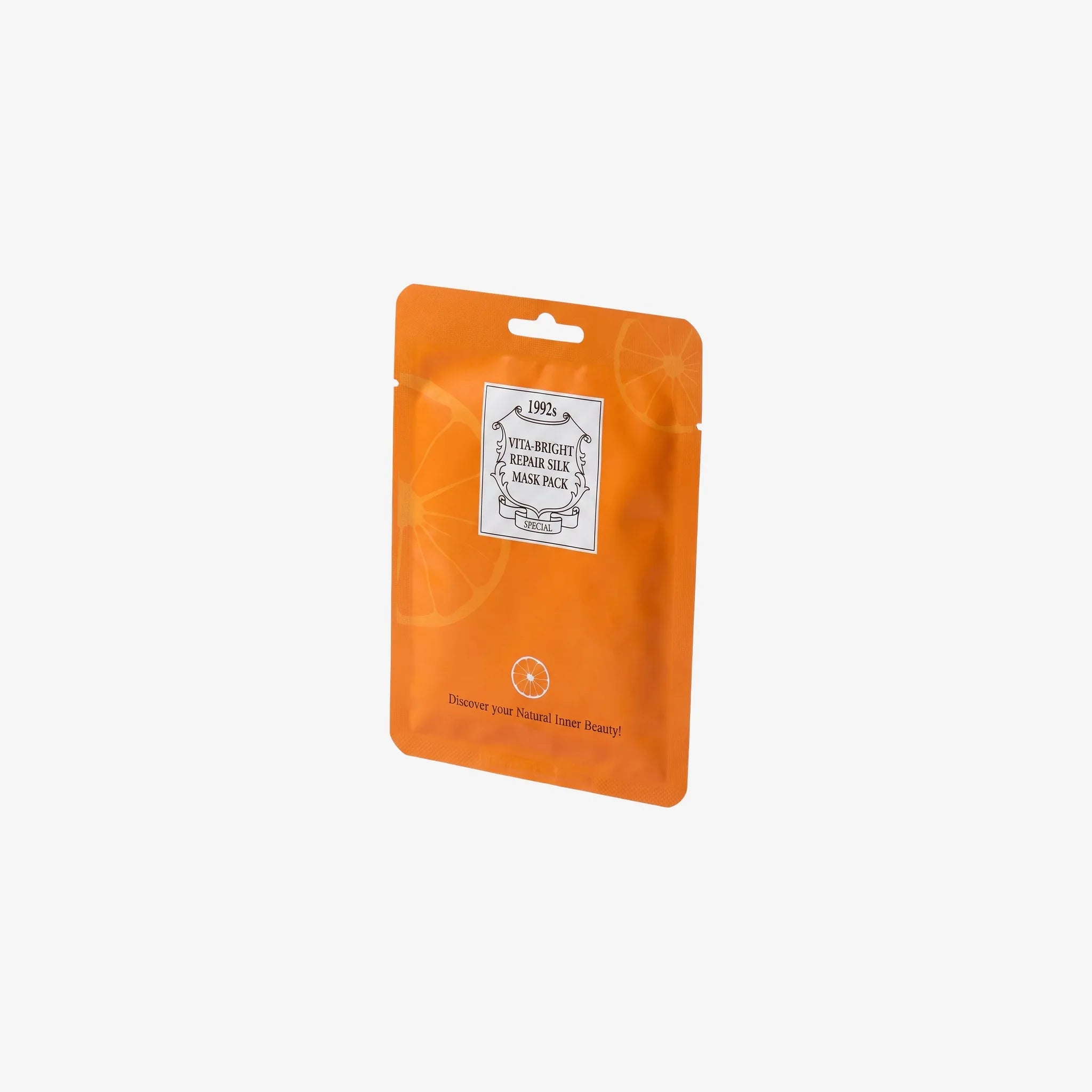 Image of Vitamin C Sheet Mask – orange sachet i vinklad studiokomposition
